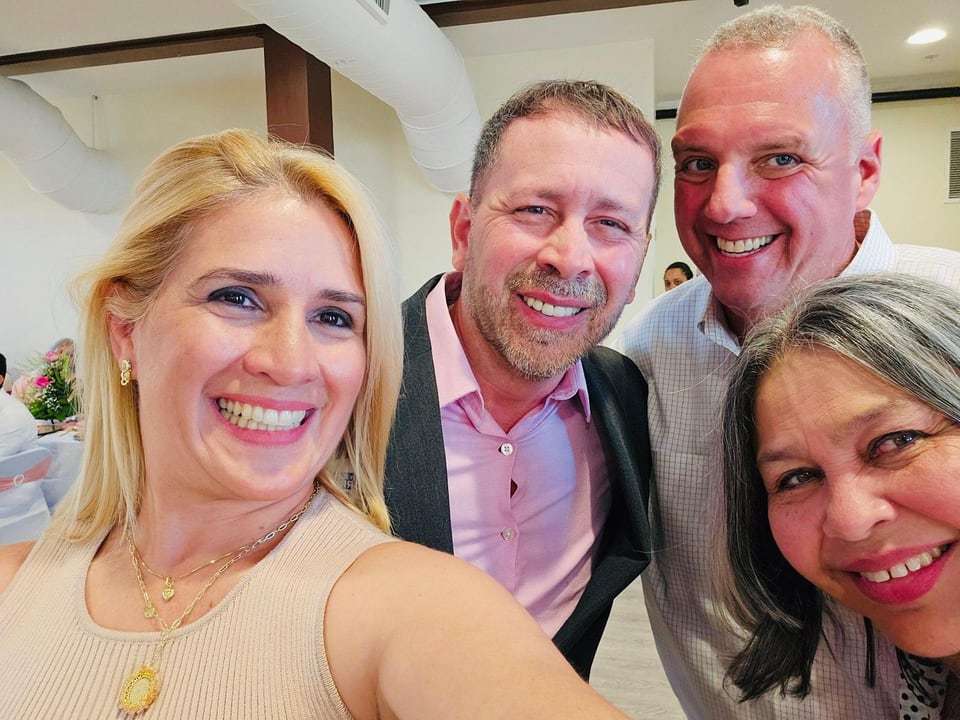 Four smiling adults crowd together for a close-up selfie, with Juan Pablo Barrera near the center.