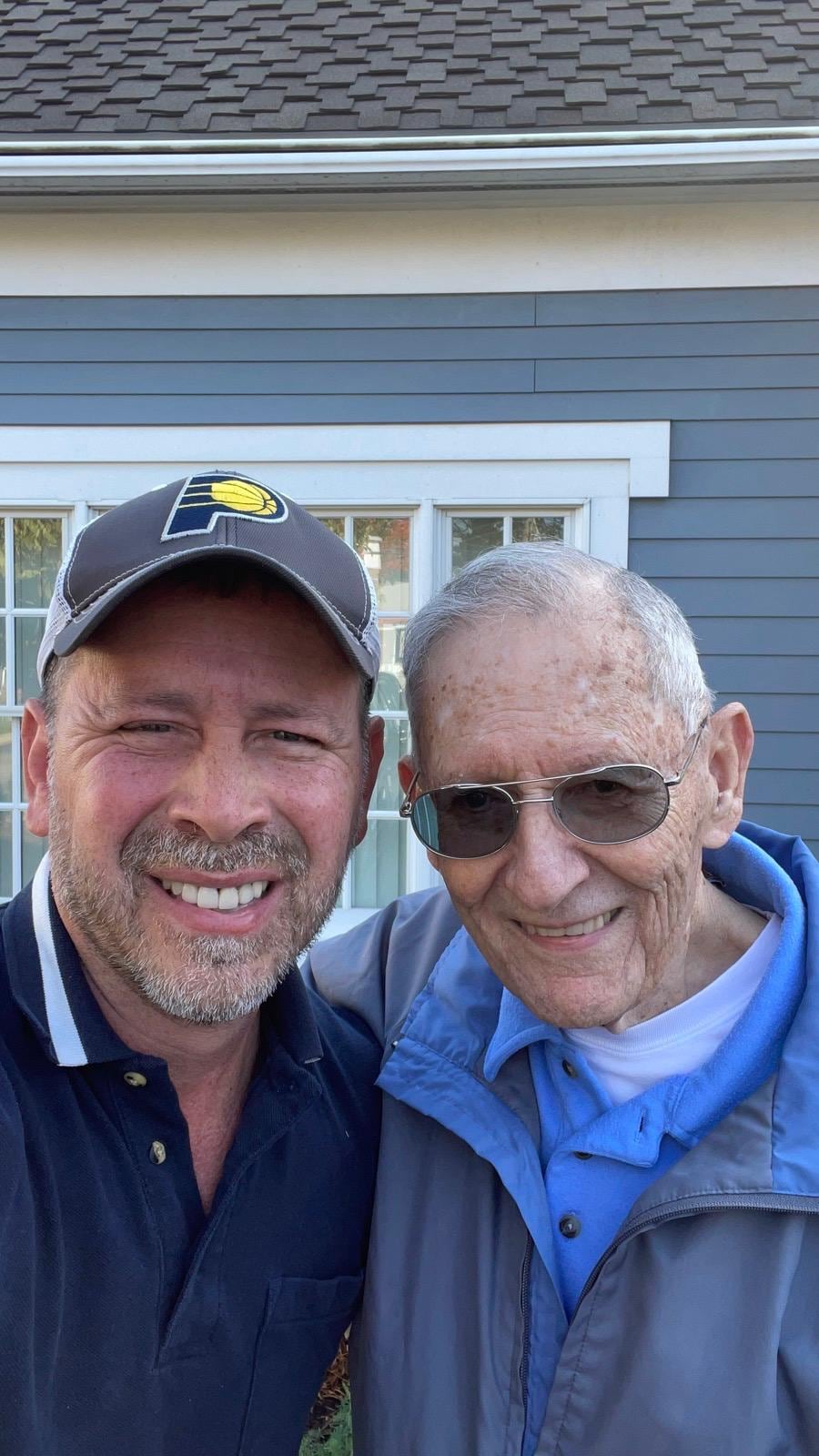 Juan Pablo Barrera takes an outdoor selfie with an older man wearing sunglasses.