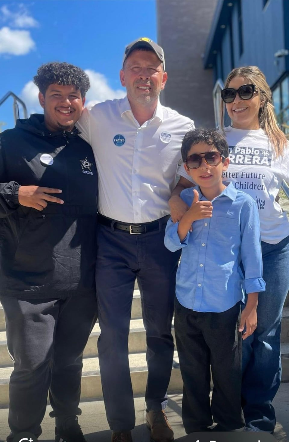 Juan Pablo Barrera poses with three people outdoors under a bright blue sky.