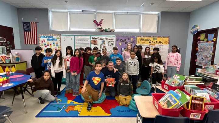 Juan Pablo Barrera with students and adults in a classroom setting.